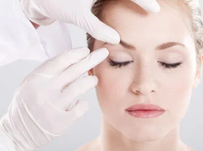 A woman getting above her eye examined by a med spa expert
